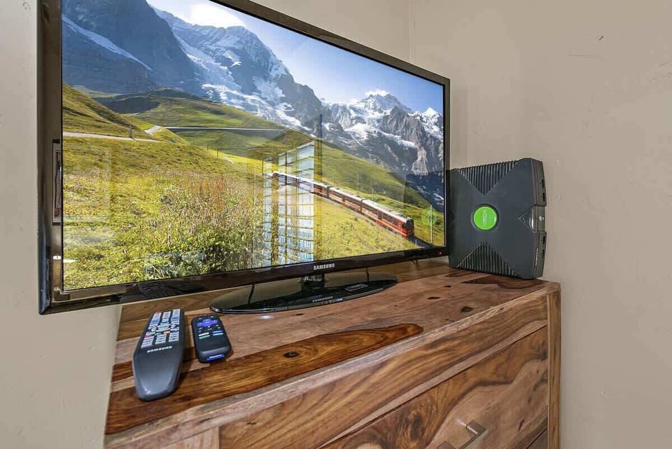 Twin bedroom has tv with Xbox and a large variety of games