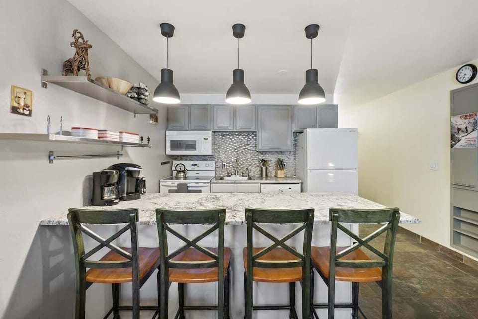 Kitchen, stocked with fridge/freezer, oven/range, microwave, dishwasher, toaster, Keurig, crockery (plates, cups, bowls), flatware (knives, forks, spoons), and cookware. You will also find the clothes washer here as well.