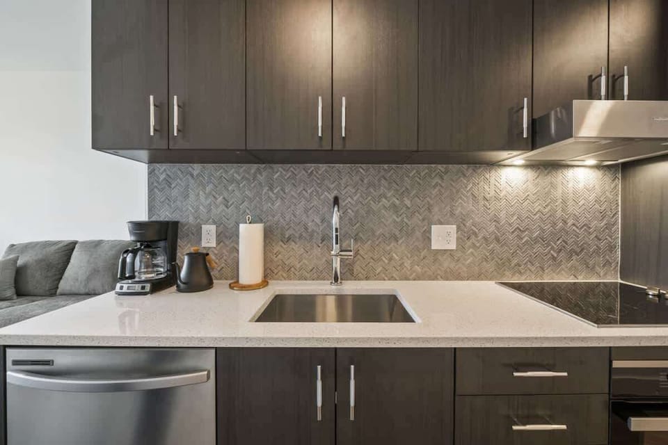 Large kitchen with plenty of cupoards, dishwasher, sink, stove top