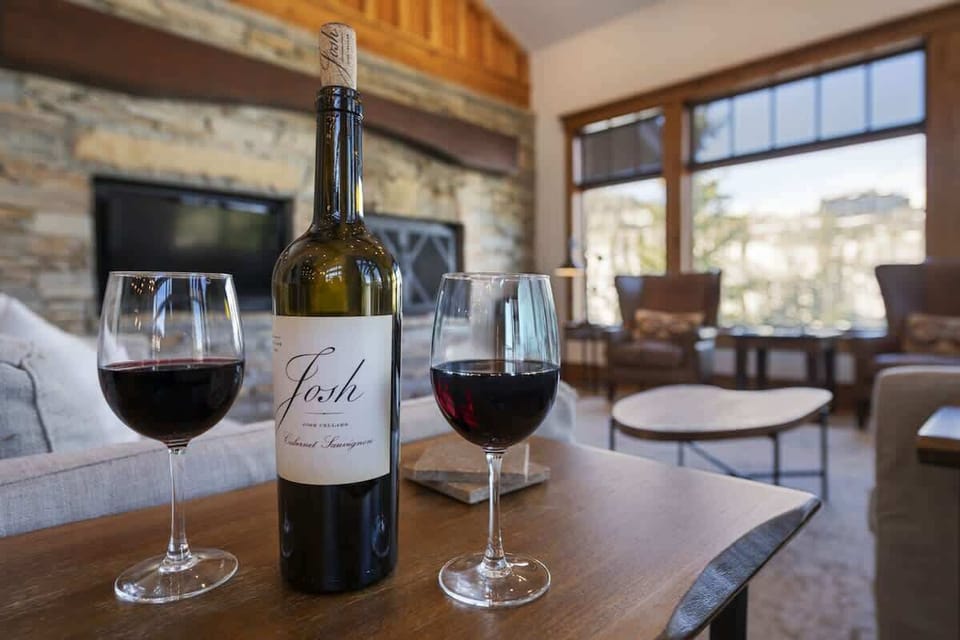 Cozy moment by the fire — unwind with a glass of wine and mountain views.
