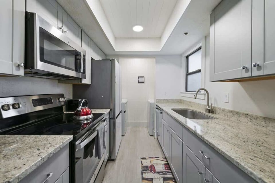 Modern kitchen with stainless steel appliances, granite countertops, and ample cabinet space — fully equipped for your stay.