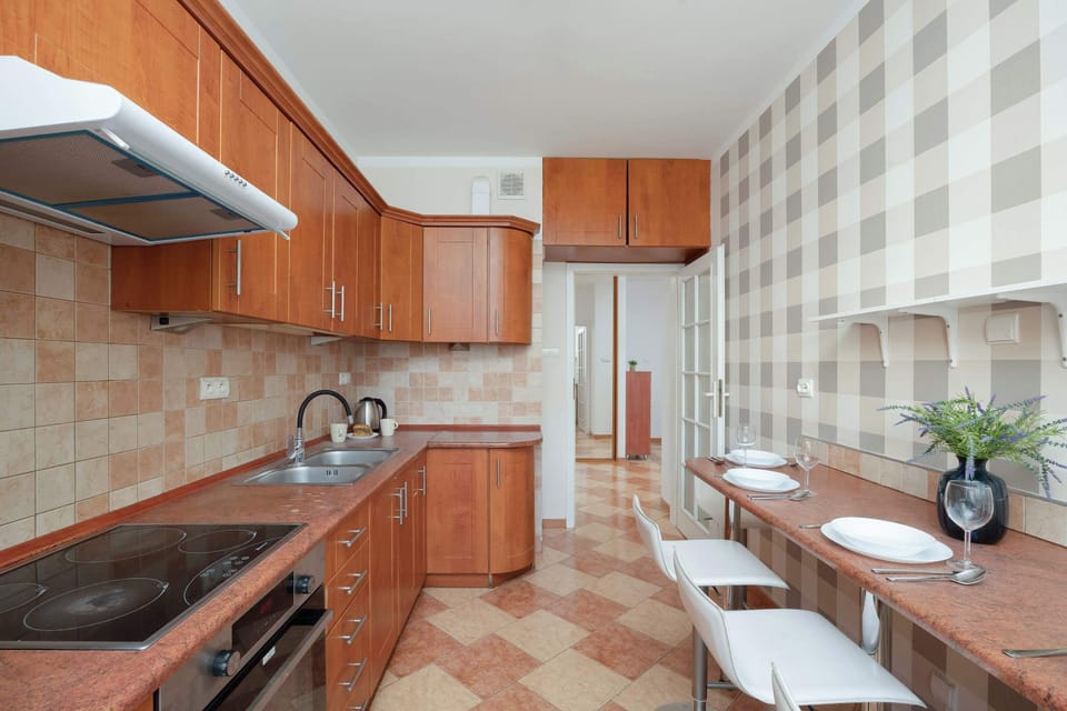 Another view of the kitchen showcasing the cooking area with ample counter space and wooden cabinetry. It has a neat and functional layout.