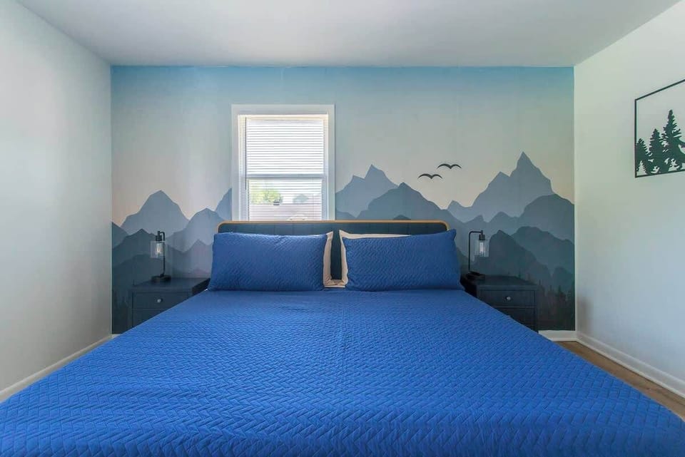 King Bedroom: Drift to sleep surrounded by serene peak murals and modern charm!