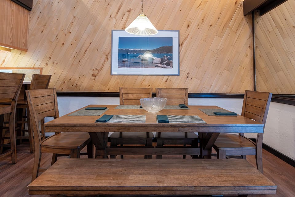 Serve relaxed dinners around the rustic table under warm pendant light.
