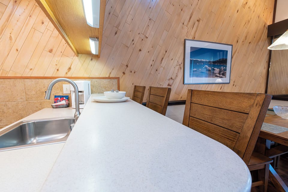 Prep snacks on spacious counters under warm, cabin-style lighting.
