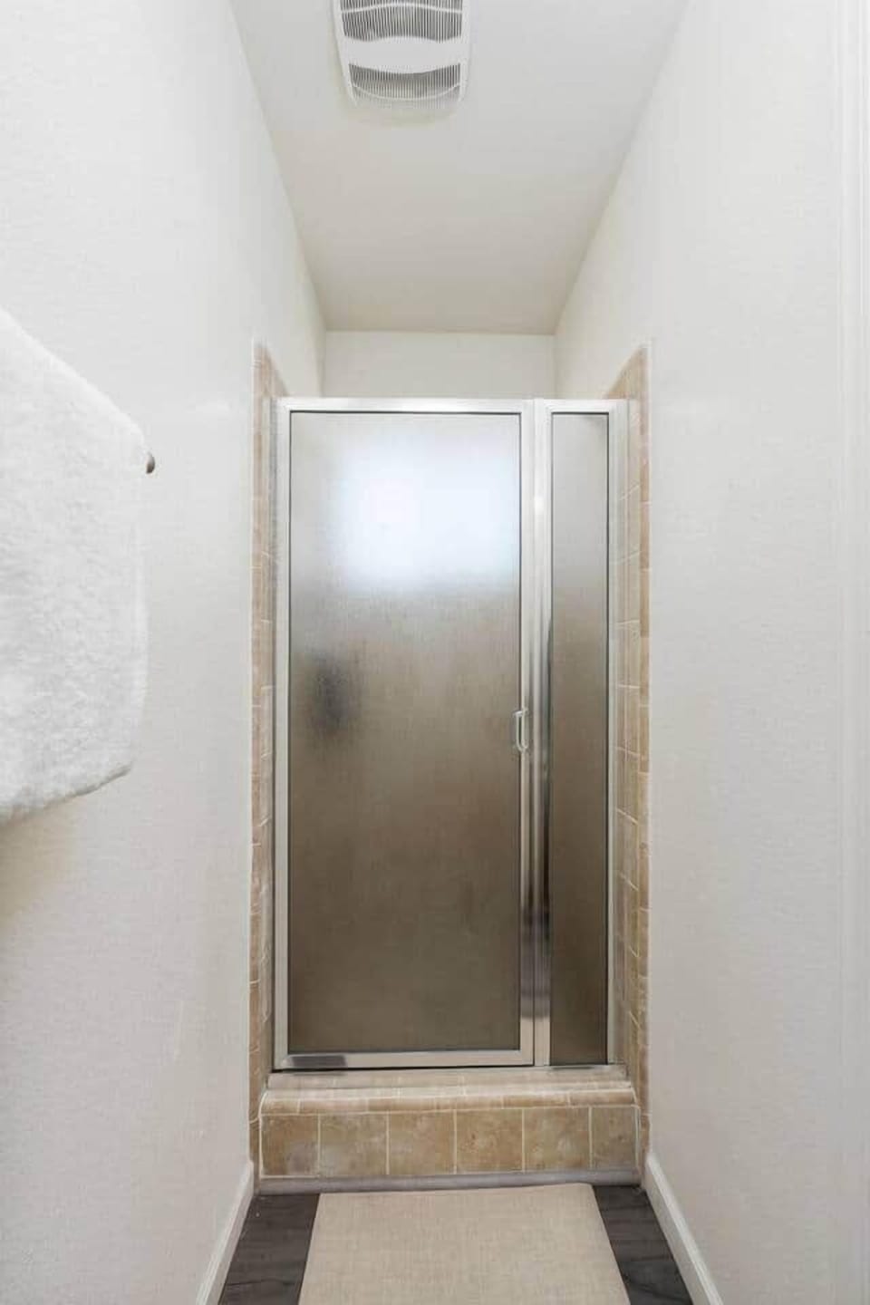 Glass shower with full amenities such as body soap, shampoo, and conditioner.