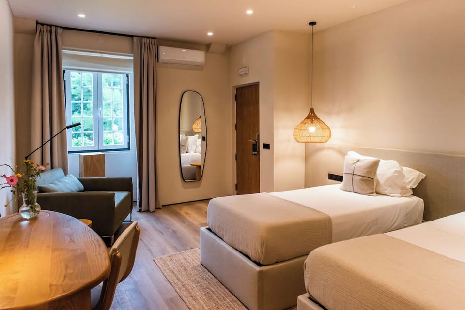 Settle into a modern room with plush beds and soft light.