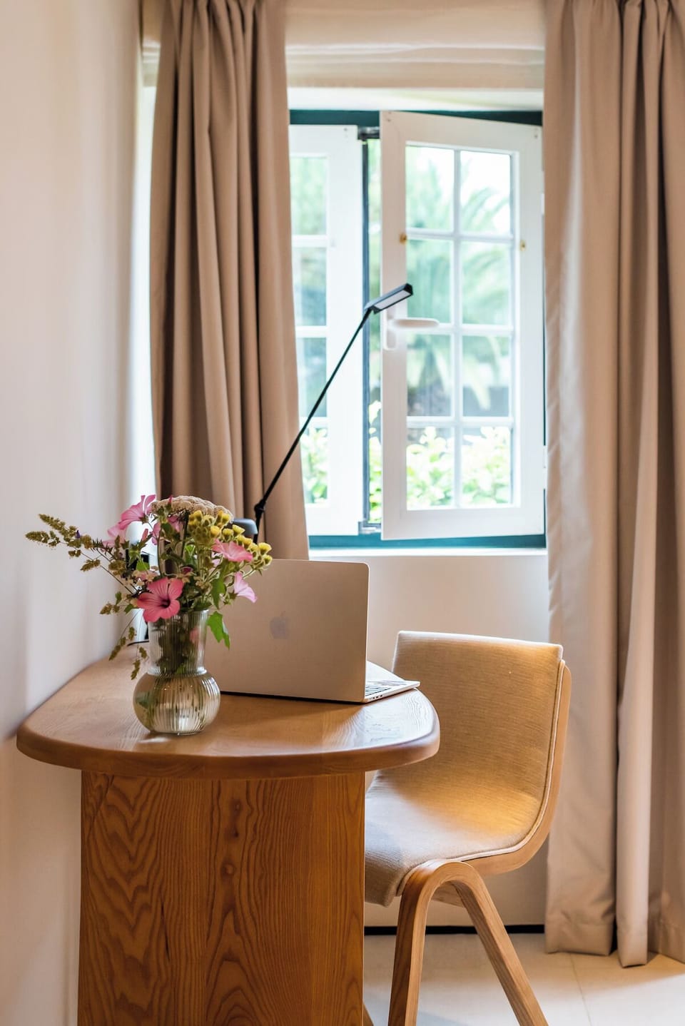 Sip morning coffee beside sunlit views and a calm workspace.