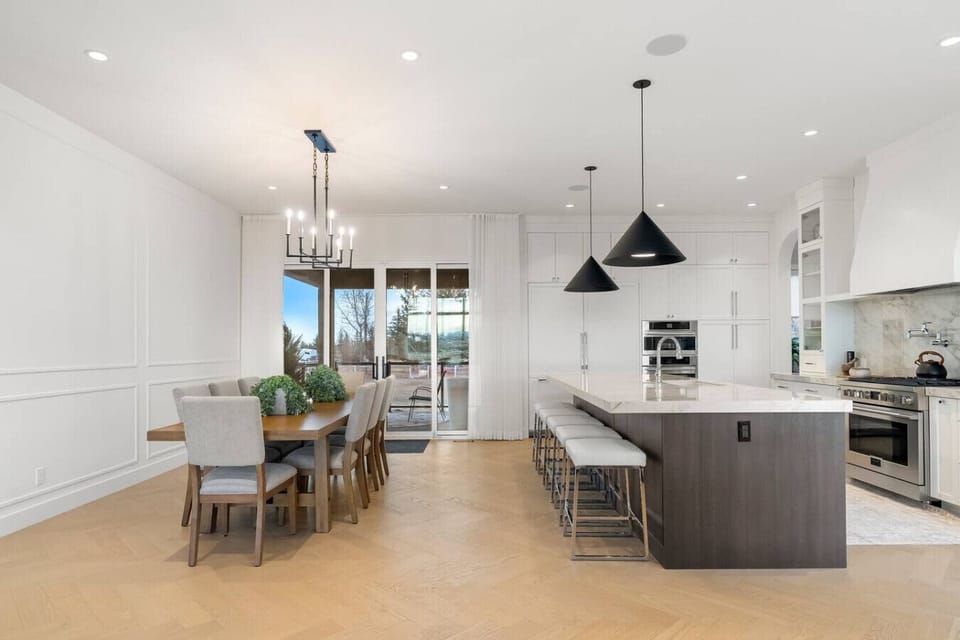 Dining area with seating for 8 at the table, and 5 at the kitchen island.