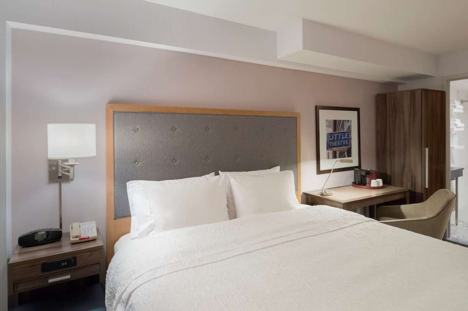 Cozy guest room with plush king bed, desk, and warm lighting