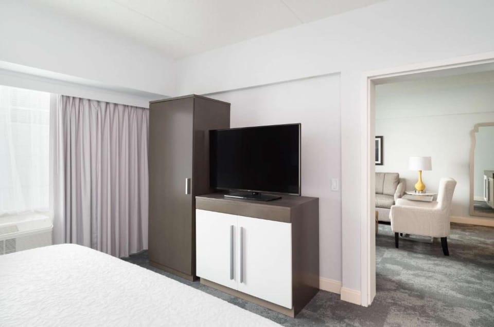 Bedroom view with TV, cabinet, and entry to sitting area