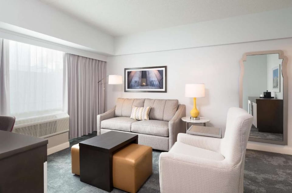 Living area with sofa, armchair, and large window for daylight