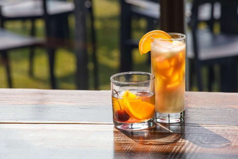 Two refreshing drinks with orange slices on a wooden table
