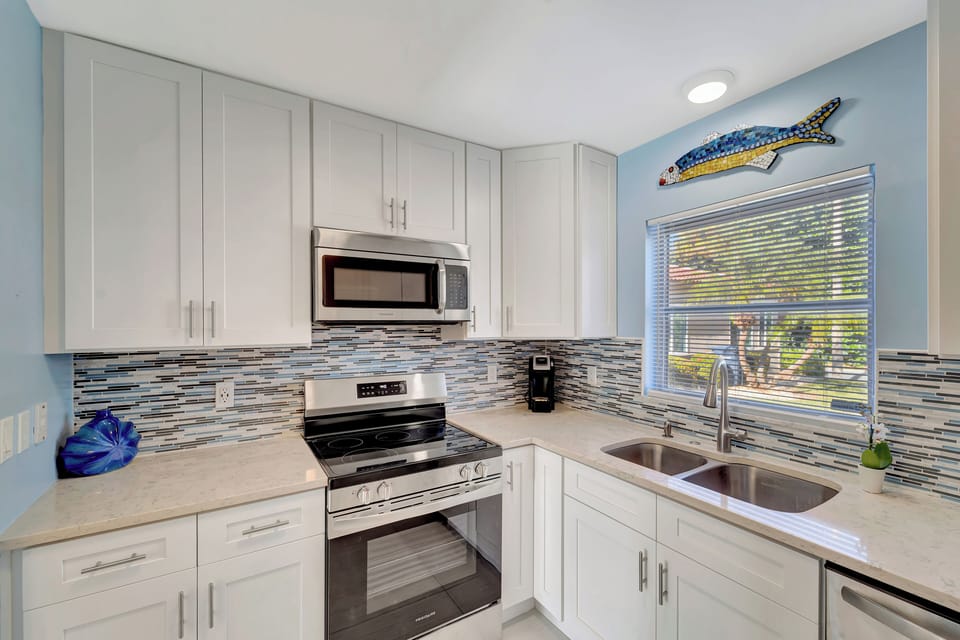Coastal kitchen equipped with coffee maker, modern appliances and supplies