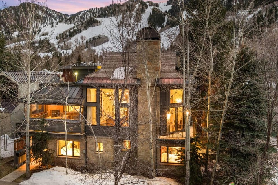 Outside of the Townhome Lit Up at Night with Aspen Mountain in the Background