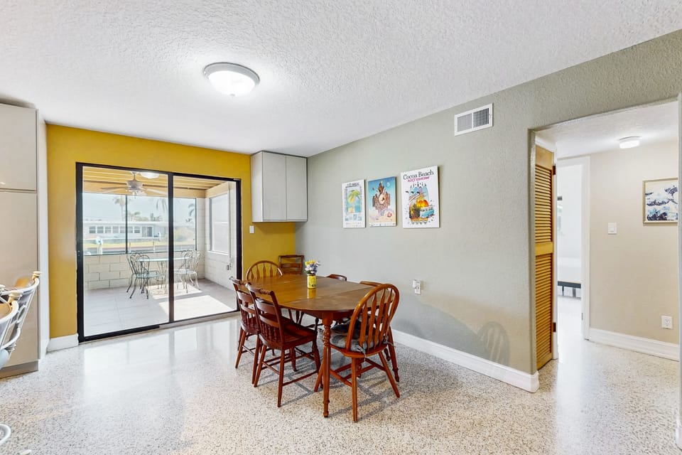Sliding glass doors from kitchen leads to large outdoor screened-in patio