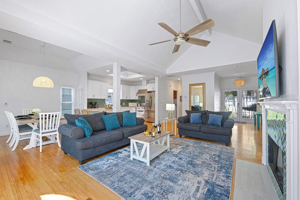 With cozy seating around a beautiful tiled fireplace and a modern coastal aesthetic, it's perfect for relaxing after a day at the beach