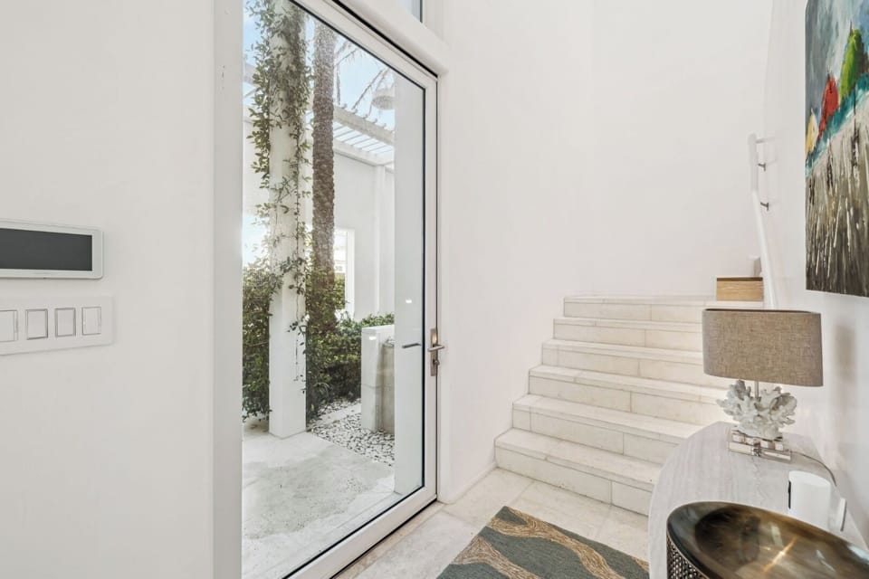 Step inside to a bright, welcoming entry with greenery.