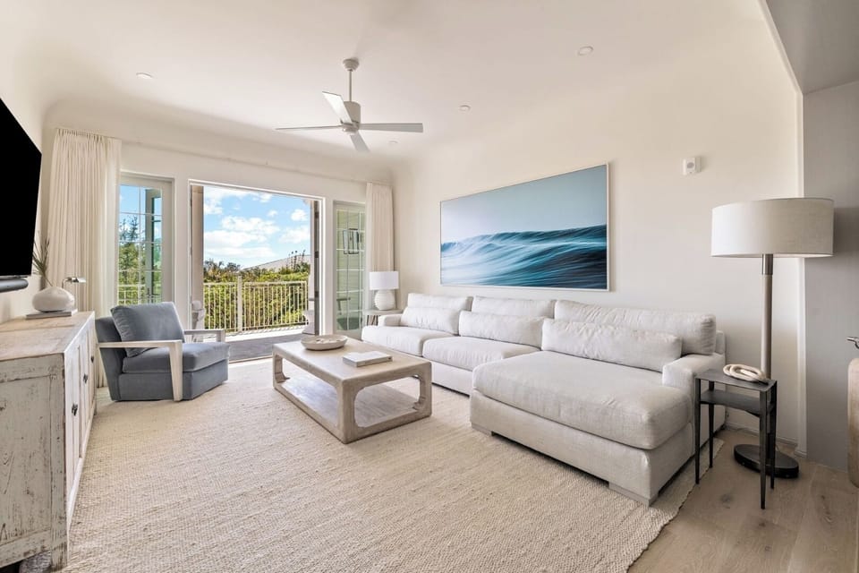 Lounge on the plush sectional beside sunlit balcony doors.