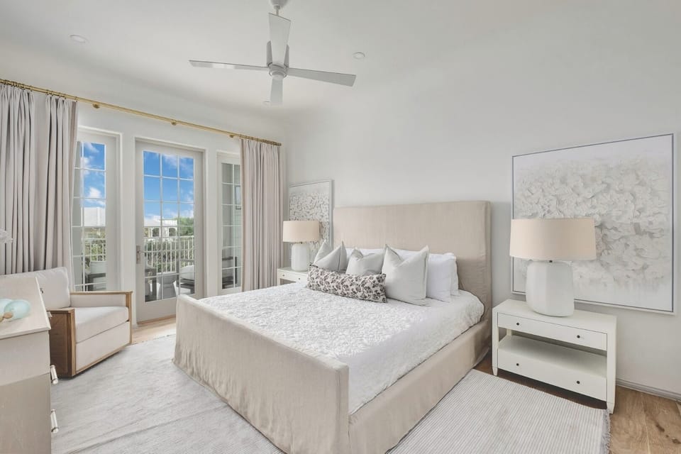 Unwind in a serene bedroom with sunlit balcony doors.