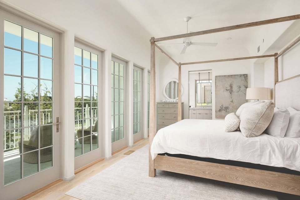 Wake refreshed beside sunlit doors opening to the balcony.