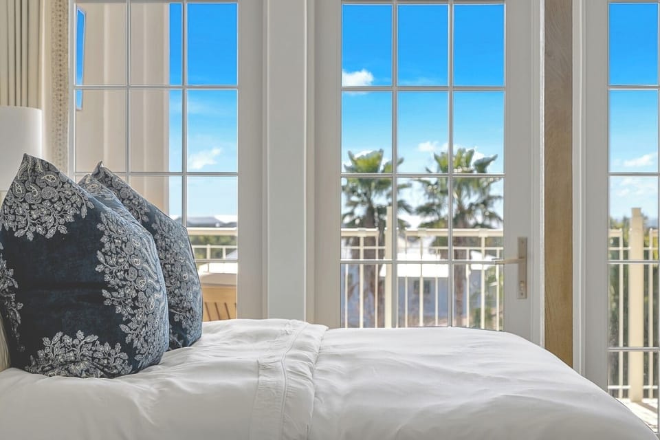 Wake gently to sunlight pouring through airy French doors.