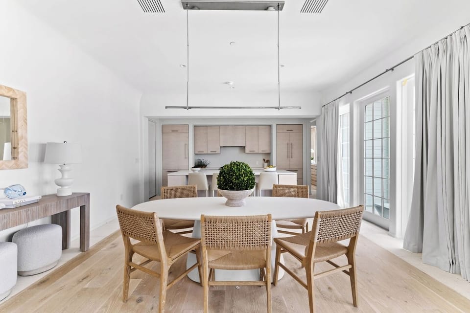 Share long meals at the inviting table under modern lighting.