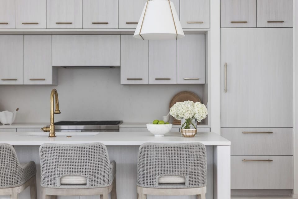 Sip morning coffee at the sleek island with golden fixtures.