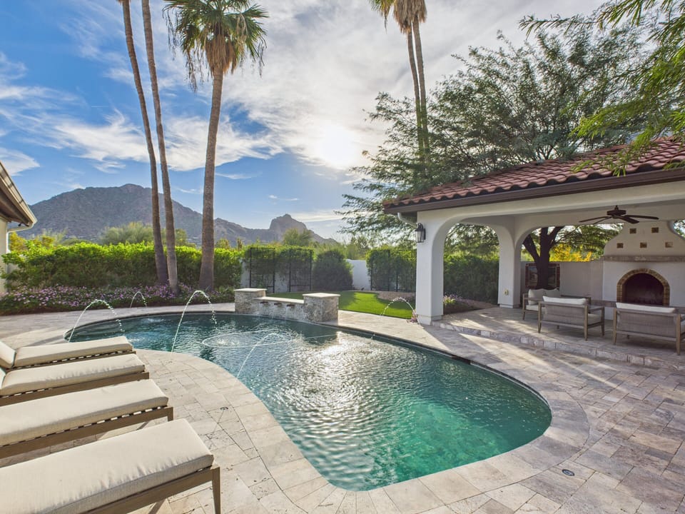 Outdoor oasis featuring a sparkling pool, lounge chairs, outdoor dining table, fire pit, and pergola with built-in BBQ grill. *Fireplace for display only.