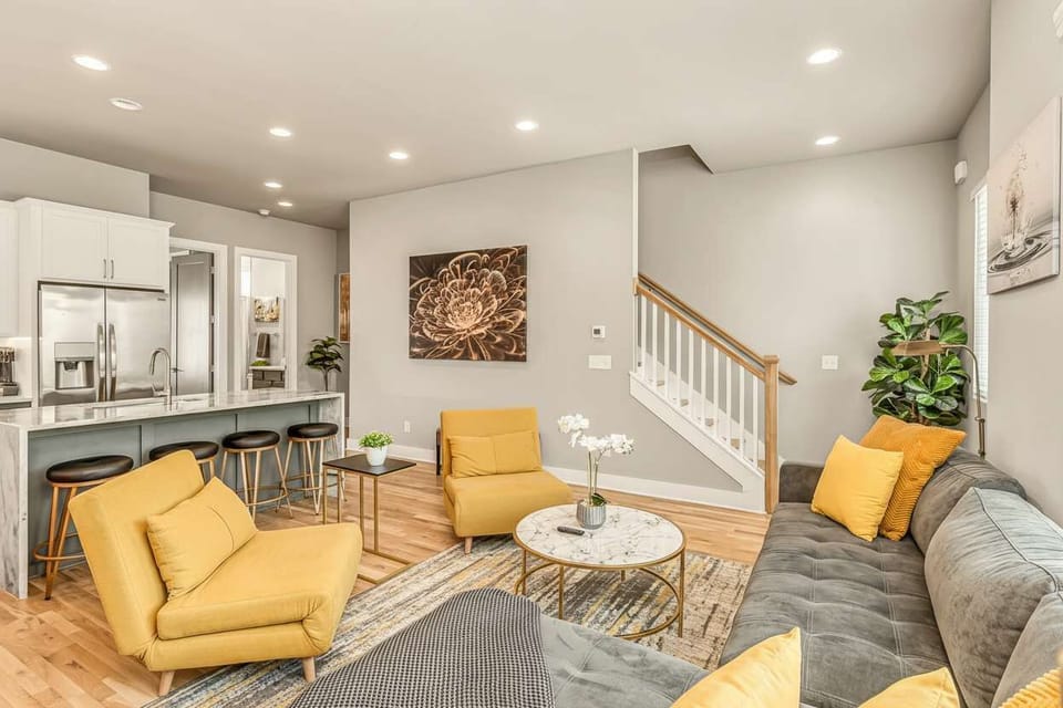 One open space: living room, hardwood floors, kitchen island, and stairs. Twelve people, zero awkward silences when everyone's on the same level