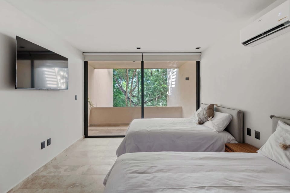 Bedroom with 2 double beds, with TV and balcony views 