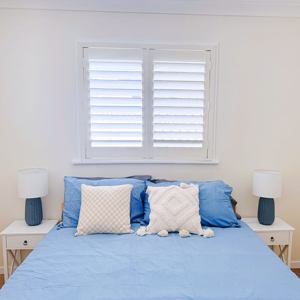Cozy bedroom with a comfy queen bed, soft lighting, and fresh linens.