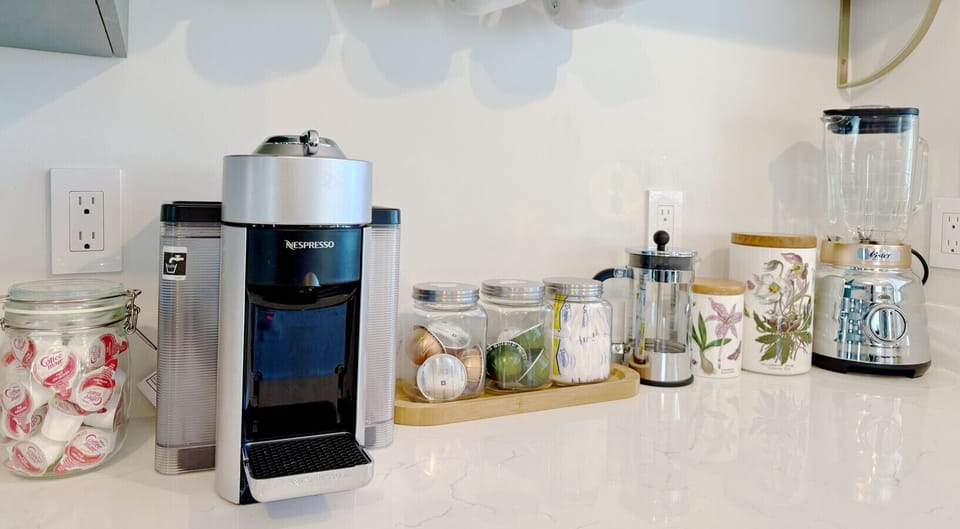 A cozy coffee and tea setup with ground coffee, a French press, sugar, creamer, tea, and a kettle ready for a relaxing morning.