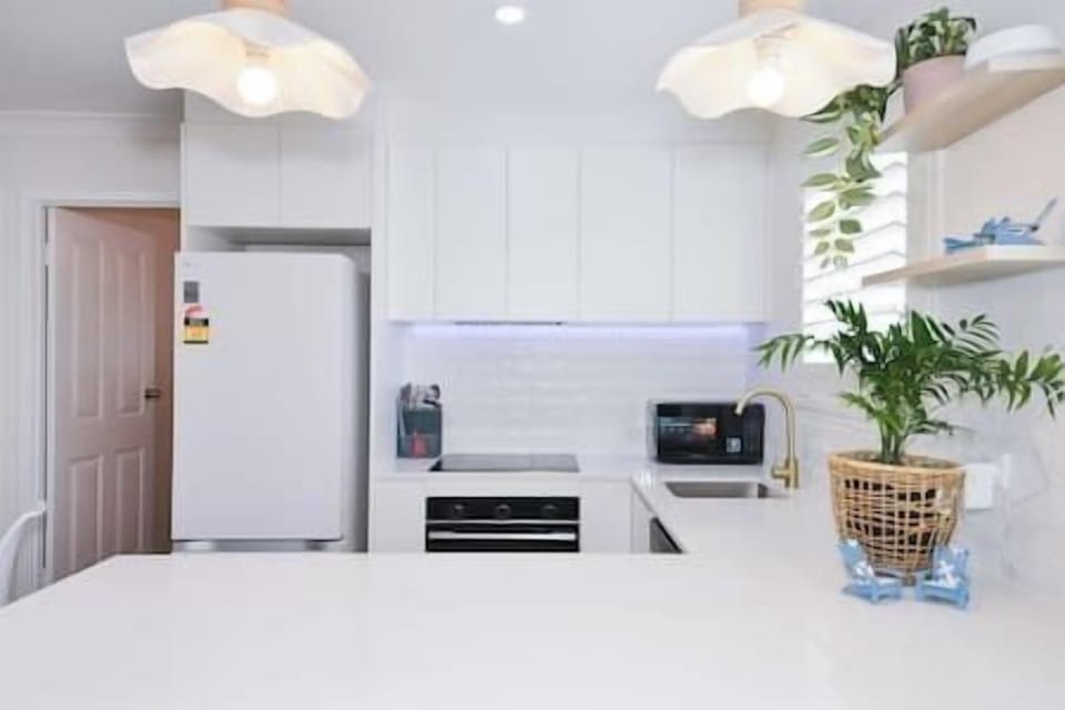 Modern full kitchen with sleek cabinetry, appliances, and spacious counters.