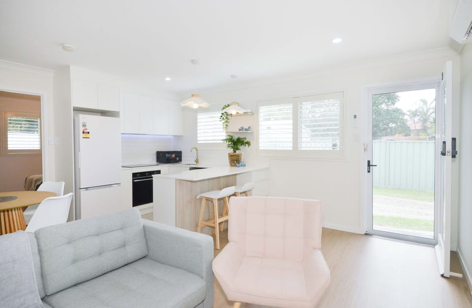 Airy lounge with cozy seating, smart TV, and seamless open-plan flow.