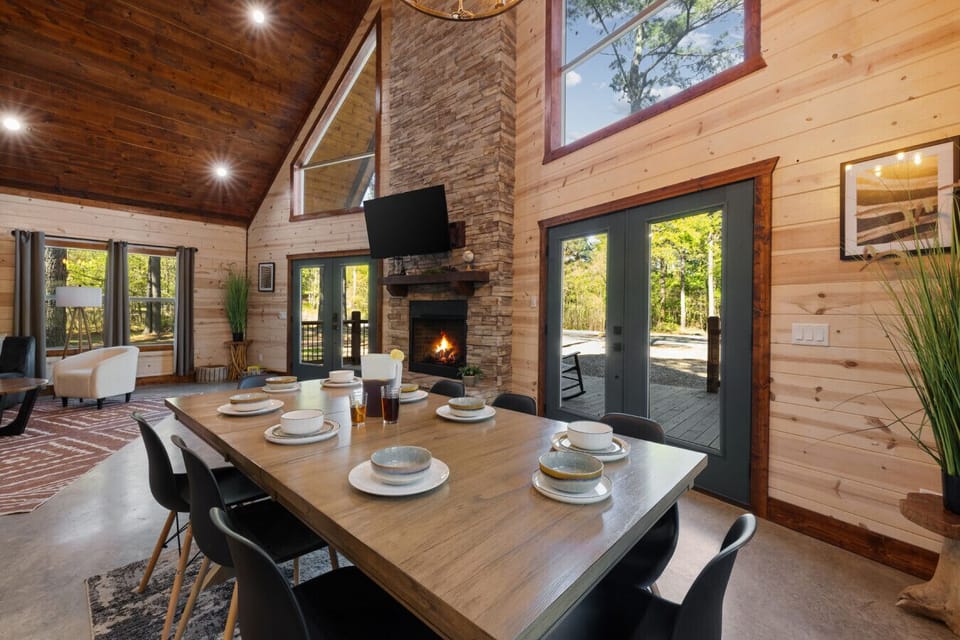 Dining table with fireplace and smart TV nearby, creating a cozy spot for long dinners, streaming your favorite shows, and unwinding together after a full day in Broken Bow