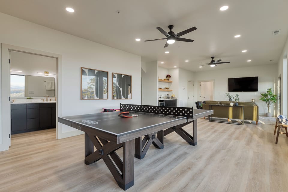 Bright game room with ping-pong table, lounge seating, and a wet bar for easy entertaining.