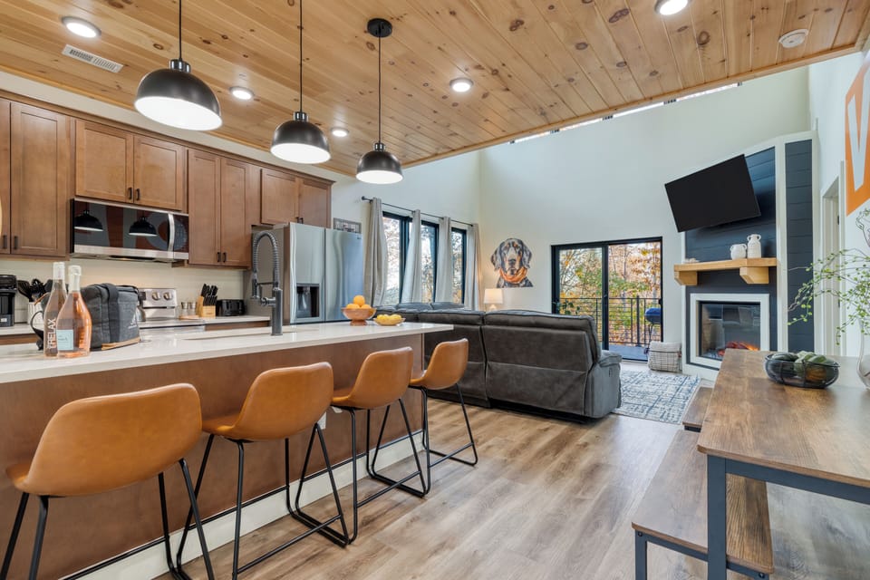 Kitchen features barstool seating and modern appliances.