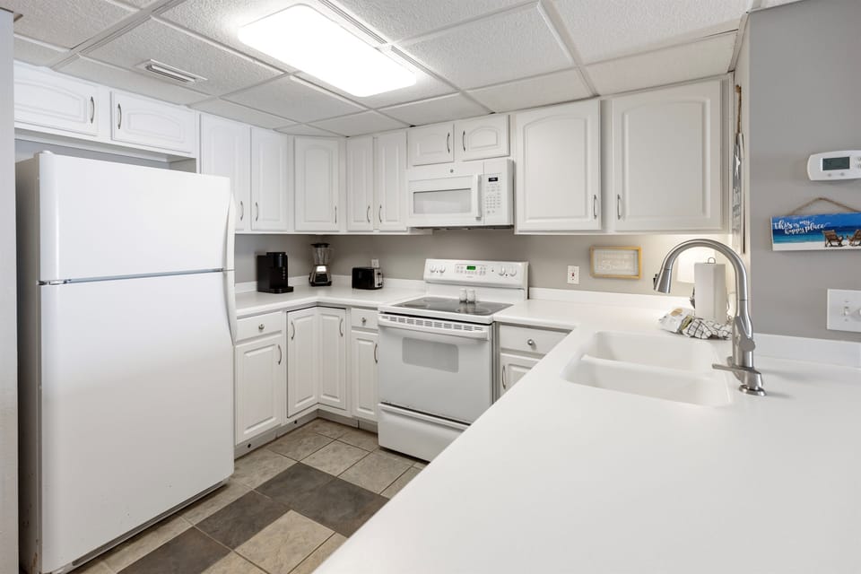 Your fully equipped kitchen offers white appliances and ample counter space for preparing meals during your stay.