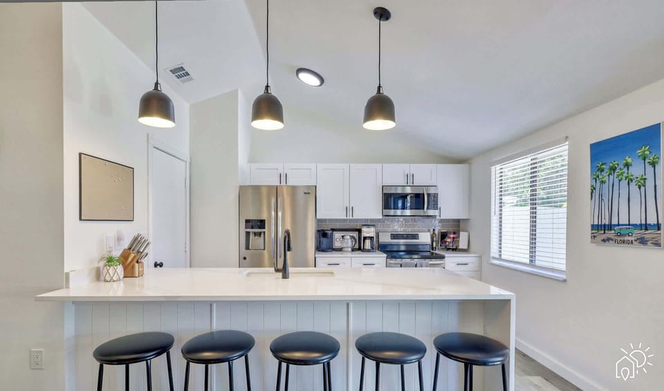 Kitchen Oasis: Sleek modern design with bright lighting and palm tree art, perfect for culinary adventures!