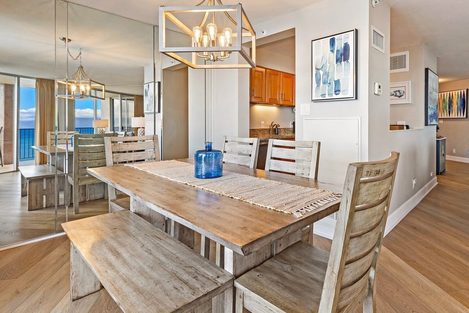 Bright dining space with a modern chandelier, coastal artwork, and a relaxed open‑concept flow.