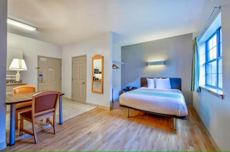 Unwind in a bright studio room with comfy bed and space.