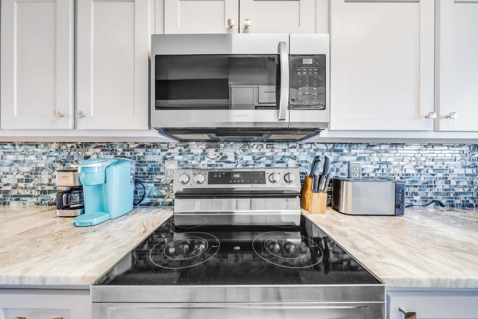 The updated, fully equipped kitchen features quartz countertops, stainless-steel appliances, and has everything you need to prepare meals for family & friends.