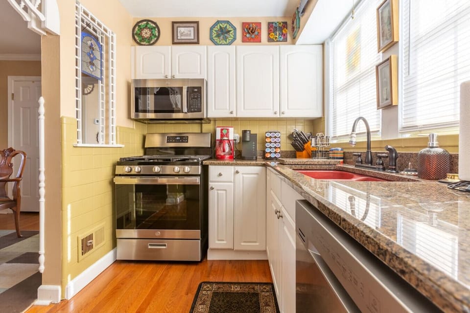 stainless-steel kitchen equipped with gas range, microwave, and fully stocked cabinetry