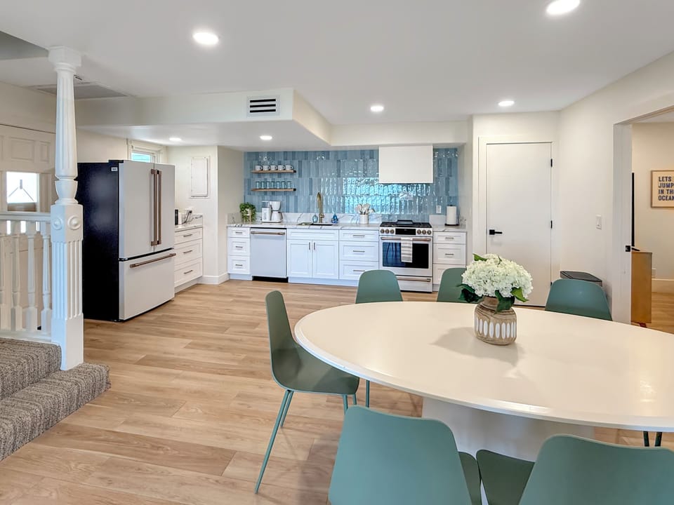 Step into your open-concept kitchen with stunning blue tile backsplash and spacious dining area, perfect for memorable meals together.