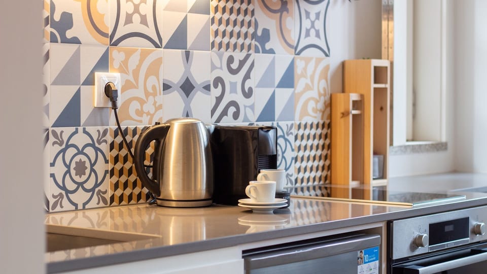 Enjoy a fully equipped kitchen with charming patterned tiles, a Nespresso machine, kettle, and all essentials for your morning ritual. #KitchenGoals #DesignDetails
