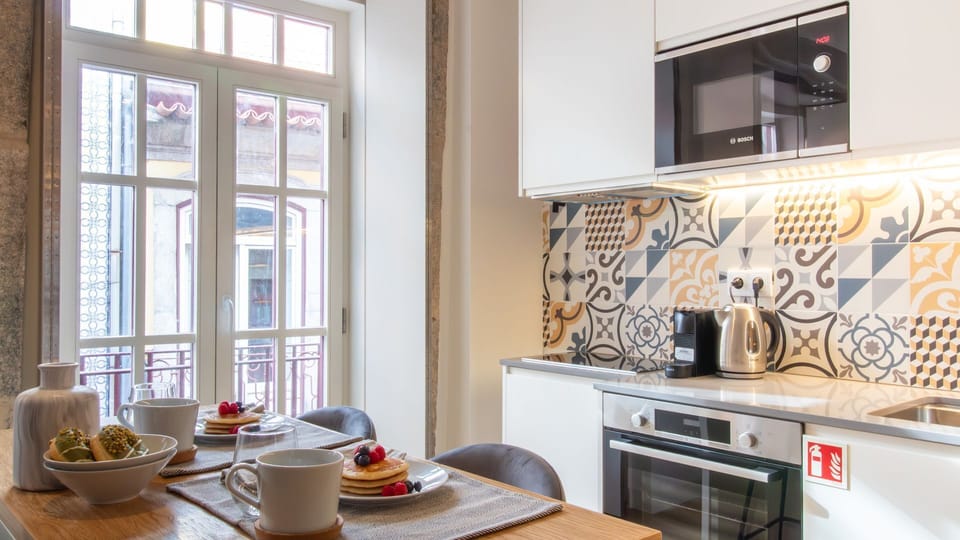 Enjoy breakfast at the island counter with views of Porto’s charming architecture – featuring modern appliances and local tile design. #BreakfastNook #ModernMeetsTraditional #PortoLiving
