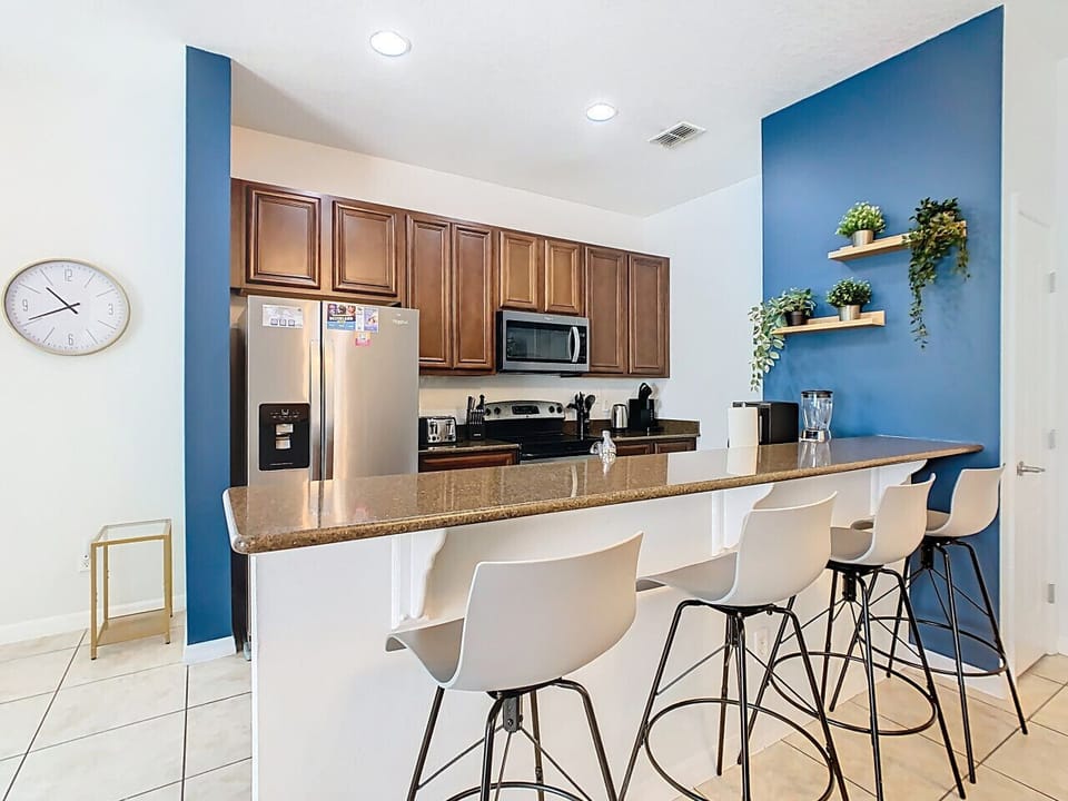 Fully equipped kitchen with stainless steel appliances and a large breakfast bar.