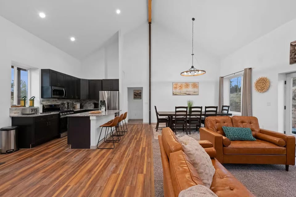 Open layout w/ vaulted ceilings, leather seating, & fireplace—calm and inviting.