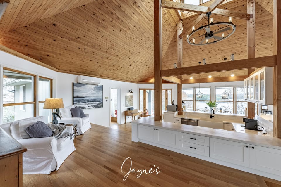 Spacious open-concept living area with vaulted ceilings and natural light